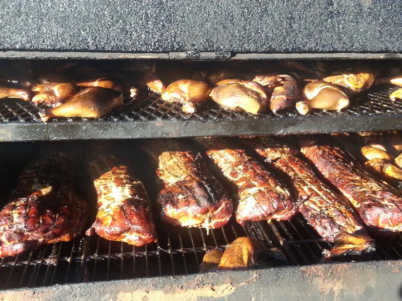 Image of chickens and boneless pork loins being smoked on one of Wolf Creek BBQ's Smokers.